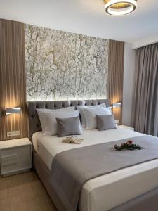 a bedroom with a large white bed with a stone wall at Elia Luxury House in Ouranoupoli +37 photos