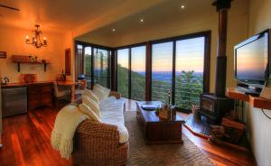 sala de estar con sofá y TV en At Remingtons Private Cottages Montville en Montville