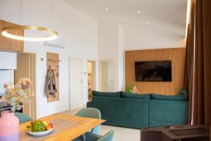 a living room with a green couch and a table at JOELL Apartments in Lokva Rogoznica