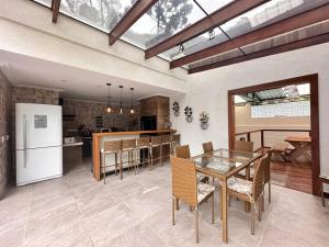 a kitchen and dining room with a table and a refrigerator at Luxo e conforto a 15 minutos do centro de Petrópolis in Petrópolis