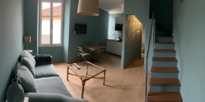 a living room with a couch and a staircase at La terrazzina OLTRE HOME HOLIDAYS in Sanremo