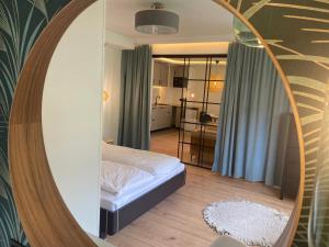 sypialnia z łóżkiem i lustrem w obiekcie Apartamenty Usteckie w Ustce