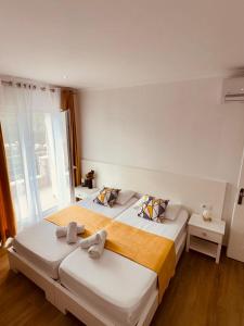 two beds in a hotel room with two bedsskirts at Orfeu apartments Ksamil in Ksamil