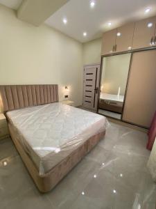 a bedroom with a large bed and a mirror at Buzovna Delmar Luxury Residence in Mərdəkan +23 photos