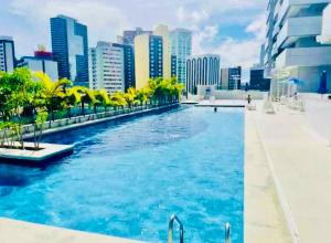 a swimming pool in a city with tall buildings at Maravilhoso! 2 suítes! Sua casa, no Salvador Prime! Wi-fi de 500 Mbps! in Salvador