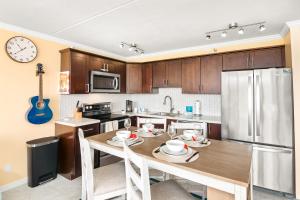 a kitchen with a table with chairs and a clock on the wall at Panoramic Mountain View Near Waikiki Beach with Parking in Honolulu