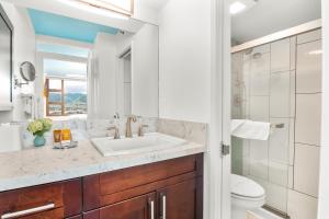 a bathroom with a sink and a toilet and a mirror at Panoramic Mountain View Near Waikiki Beach with Parking in Honolulu