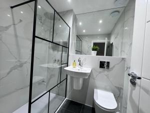 ein weißes Badezimmer mit Waschbecken und Dusche in der Unterkunft 1 Orchard Farm Cottages Sleeps 10, Open plan Kitchen & Large Garden in East Grinstead + 6 Fotos