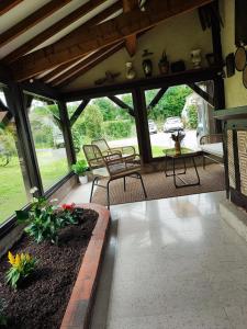 クウェットヴィルにあるLa longère dans la prairieの椅子2脚とテーブル付きポーチ