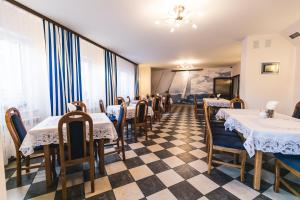 restauracja ze stołami i krzesłami oraz podłogą wyłożoną szachownicą w obiekcie Gościniec pod Żaglami w mieście Skoki Duże