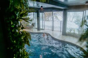 two people in a swimming pool in the snow at Falls Creek Hotel in Falls Creek