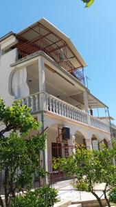 ein großes weißes Gebäude mit Balkon in der Unterkunft SunsetBeach in Grebaštica
