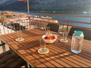 ein Holztisch mit einer Obstschale und einer Flasche in der Unterkunft SunsetBeach in Grebaštica