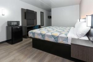a hotel room with a bed and a television at Motel 6-Cincinnati, OH in Glendale