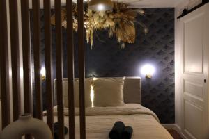 a bedroom with a crib with shoes on the bed at Le Jardin Secret - Balnéo & SPA in Montpellier