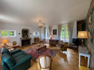 a living room with a couch and a table at La Demeure du Domaine de Tertu, 12p, PISCINE in Villedieu-lès-Bailleul