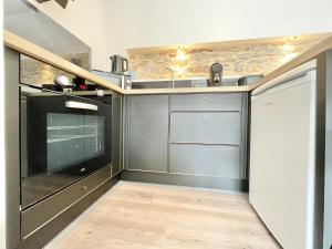 Una cocina con gabinetes negros y un fregadero. en LE CALLOCH 2G - Studio 4 Étoiles - Quartier Gare, en Quimper 4 fotos más