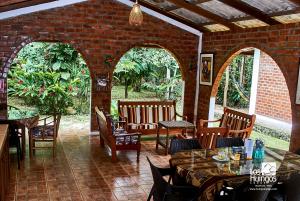 a patio with tables and chairs and a brick wall at Huingos Eco Lodge in Tarapoto