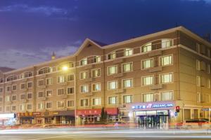 un gran edificio en una calle de la ciudad por la noche en Jinjiang Inn Dalian Lianhe Road en Dalian