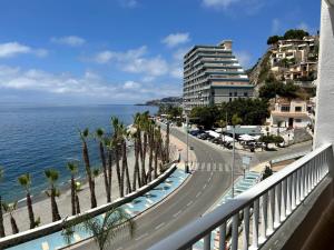 a view of a street with palm trees and the ocean at Delphinhaus in Almuñécar