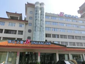 襄陽市にあるJinjiang Inn Xiangyang Nanshan Tanxi Roadの正面に看板がある大きな建物