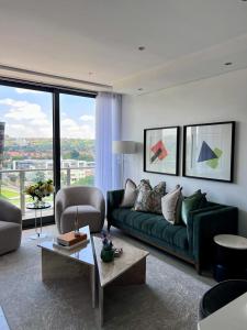 Una sala de estar con un sofá verde y una ventana grande. en Delight Luxurious Apartments, en Johannesburgo