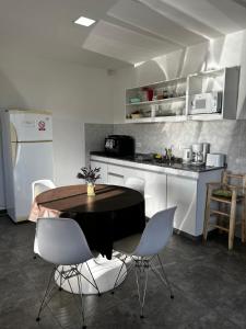 une cuisine avec une table et des chaises dans une cuisine dans l'établissement Cabañas Alma de Diamante, à San Rafael