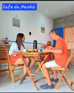 a group of people sitting at a table at Casa Tuia Holiday Flat a 2km do centro e das falesias da Praia de Morro Branco in Beberibe