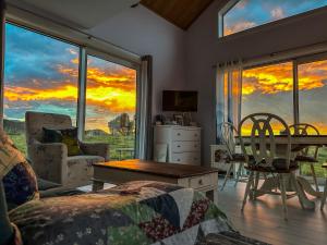 a living room with a view of a sunset at White Caps Kaikoura Farmstay in Kaikoura