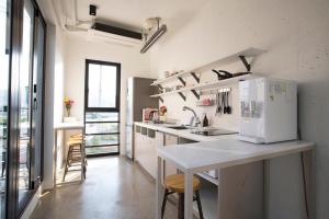 a kitchen with a counter and a white refrigerator at Baguni Hostel in Suncheon