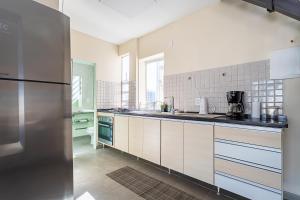 eine Küche mit weißen Schränken und einem Edelstahlkühlschrank in der Unterkunft Stella Maria Cristo Redentor e Praia in Rio de Janeiro