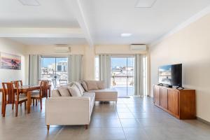 ein Wohnzimmer mit einer Couch, einem Fernseher und einem Tisch in der Unterkunft Stella Maria Cristo Redentor e Praia in Rio de Janeiro