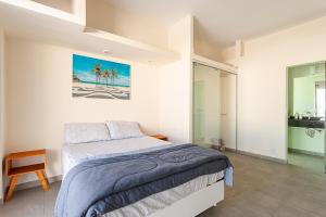 ein Schlafzimmer mit einem Bett und einem Gemälde an der Wand in der Unterkunft Stella Maria Cristo Redentor e Praia in Rio de Janeiro