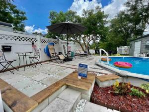 a backyard with a swimming pool and an umbrella at Pool - Beach Supplies - Outdoor Shower - PingPong Table in Bradenton
