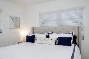 a bedroom with a large white bed with blue pillows at Pool - Beach Supplies - Outdoor Shower - PingPong Table in Bradenton +53 photos
