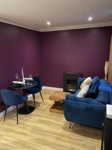 a living room with a blue couch and a table at Le Cocon des Granges - Suite Sauna Jaccuzi SPA in Bonnières-sur-Seine