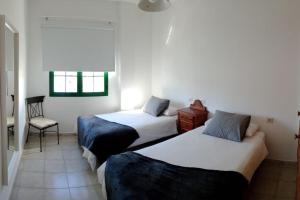 una stanza d'albergo con due letti e una sedia di Apartmento Ito a Playa Blanca