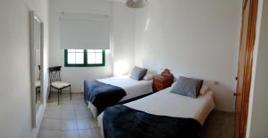una stanza d'albergo con due letti e una sedia di Apartmento Ito a Playa Blanca
