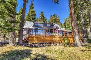 a log home in the woods with trees at Reflections Lakeview Cabin - Private Beach Access, Hot Tub & Buoy! in Carnelian Bay
