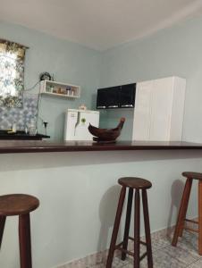 a kitchen with two bar stools and a counter top at APARTAMENTO SIMPLES E ACONCHEGANTE in Paraty