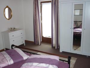 1 dormitorio con cama, espejo y ventana en Landhaus Wildfeuer, en Kirchdorf im Wald