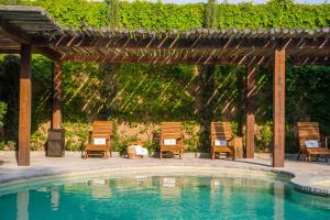 a pool with chairs and a wooden pergola at Viñedos San Lucas in San Miguel de Allende