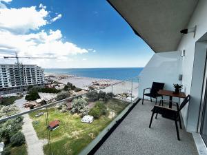 a balcony with a desk and a view of the ocean at Luna Studio White Tower in Mamaia