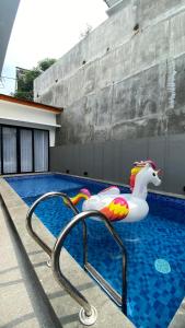 Una piscina con un paseo inflable de unicornio en ella. en Eben Haezer Villas, en Karangploso