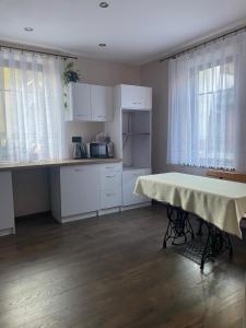 a kitchen with a table in the middle of a room at Apartament Nowy Targ in Nowy Targ
