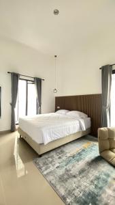 a bedroom with a large bed and a chair at Eben Haezer Villas in Karangploso +14 photos