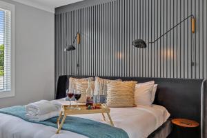 Una cama con una mesa con copas de vino. en Tenor - Private Rooftop - 8 mins to Broadway, en Nashville