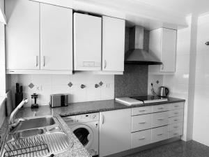 a kitchen with a sink and a washing machine at Nova Beach in Oeiras