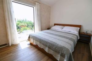 a bedroom with a bed and a large window at Holiday home in Moscenicka Draga 43083 in Kraj