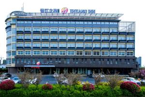 een groot gebouw met een bord erop bij Jinjiang Inn Yancheng Dongtai Municipal Government in Dongtai